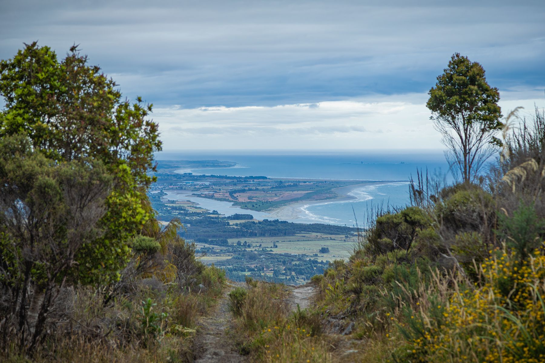 View from the Denniston plateau looking down over the Buller river mouth, farmland and the coast towards Westport.