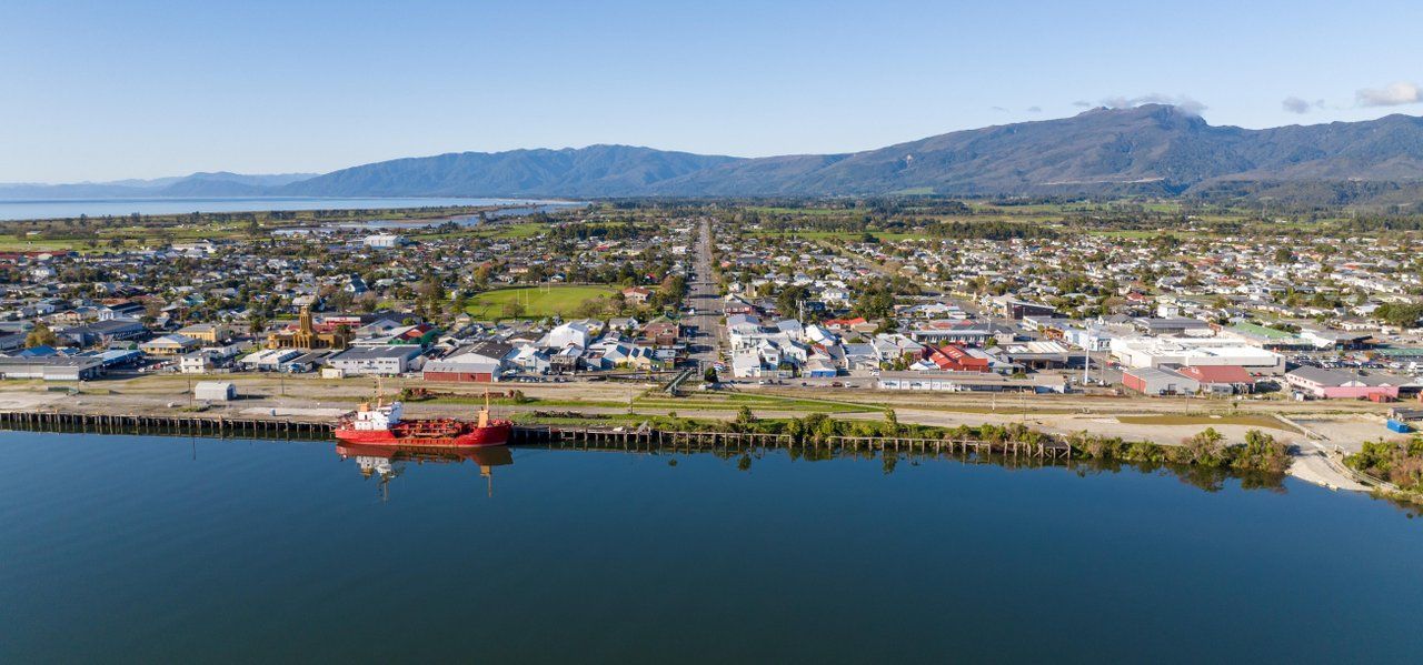 A ship at the Westport wharf with the town and ranges behind.